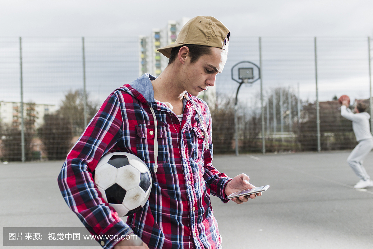 年轻足球运动员与智能手机