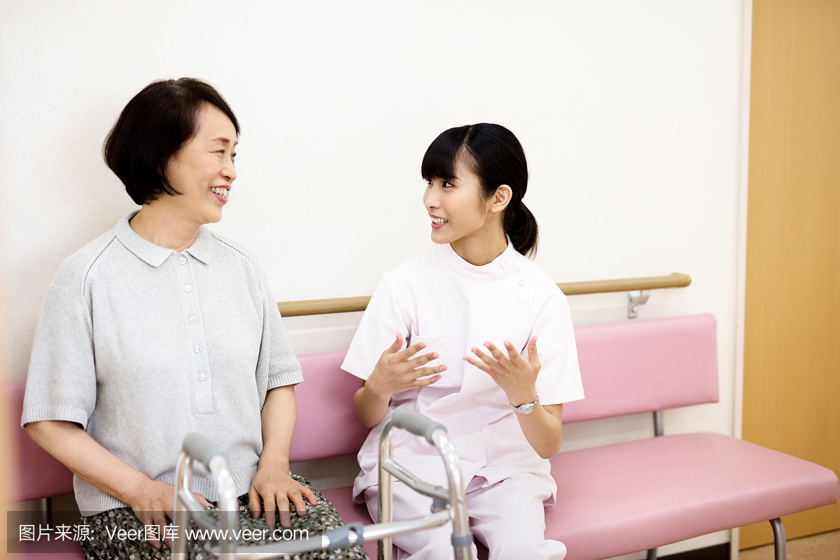 Japanese nurse talking to senior woman in hos