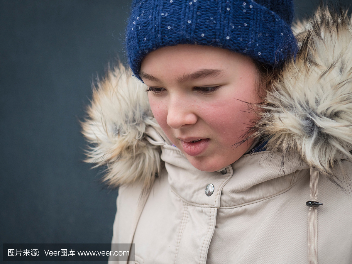 女孩在冬天期间戴编织帽子和皮大衣的特写镜头