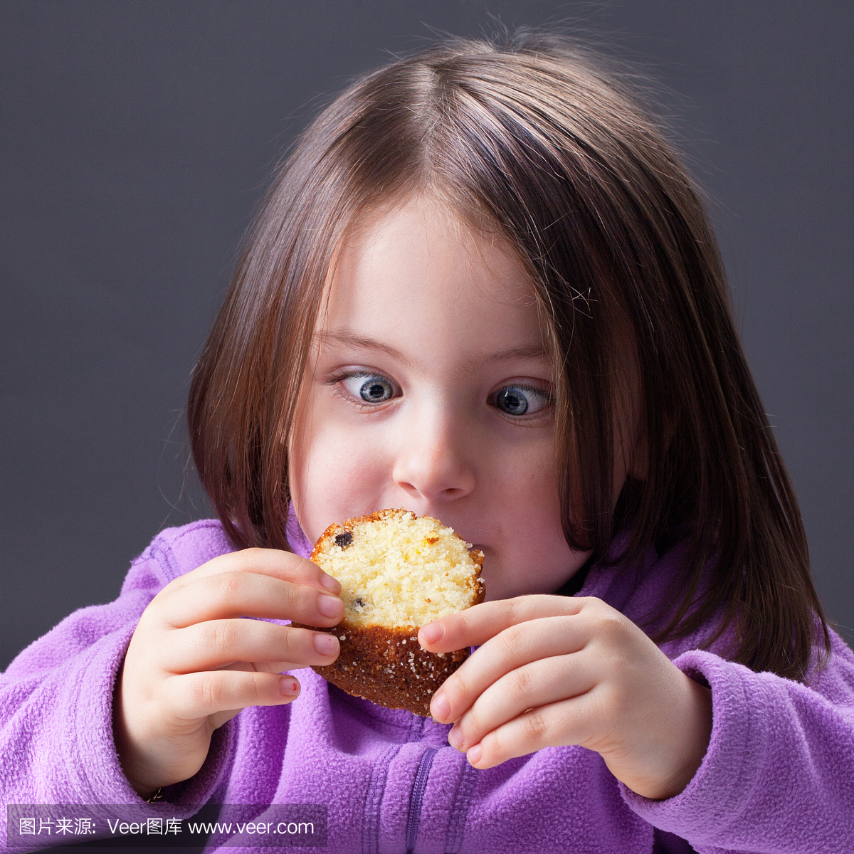 饥肠辘辘的饥饿的小女孩吃了一块蛋糕
