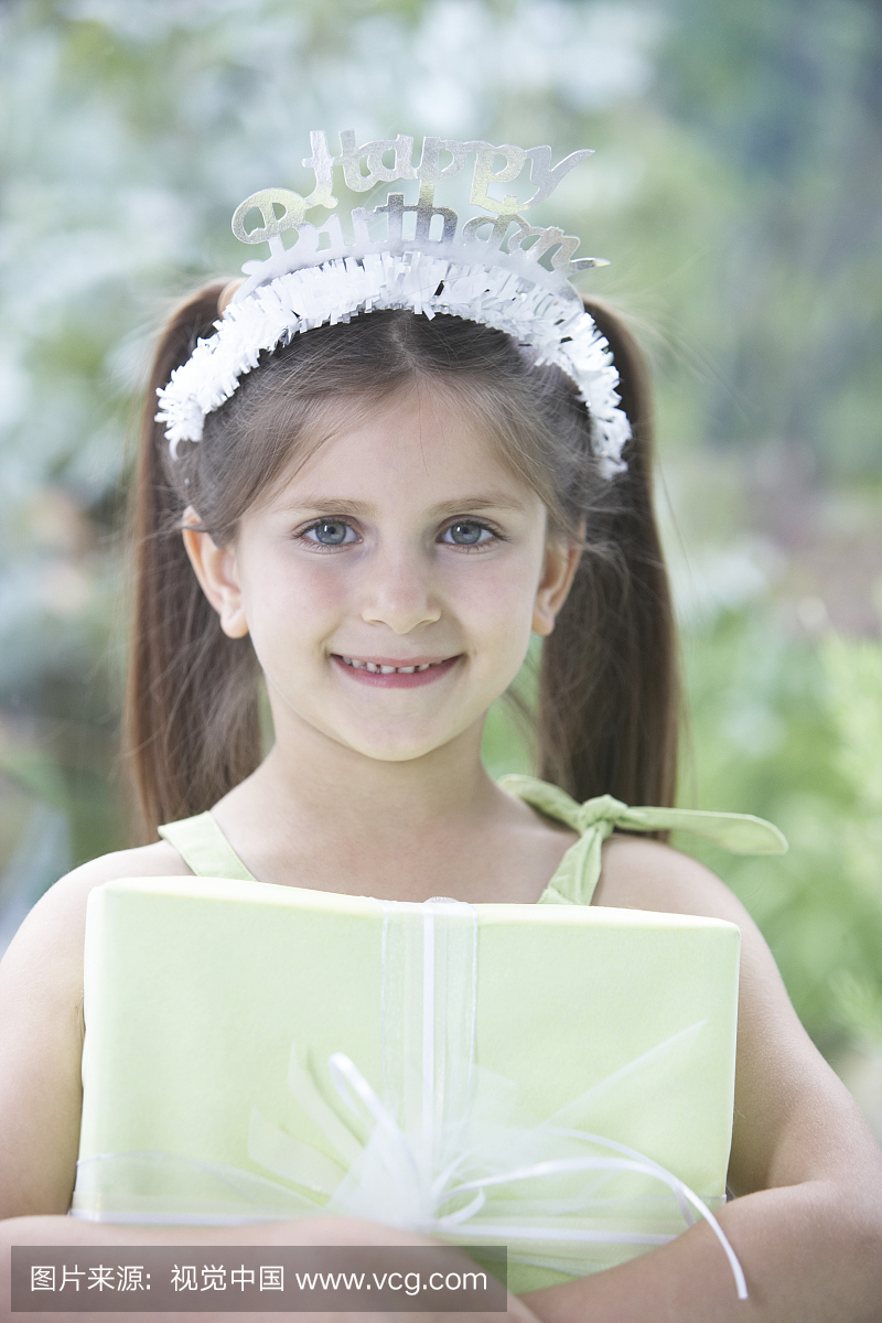 戴着生日快乐冠的女孩(6-8),拿着礼物,肖像