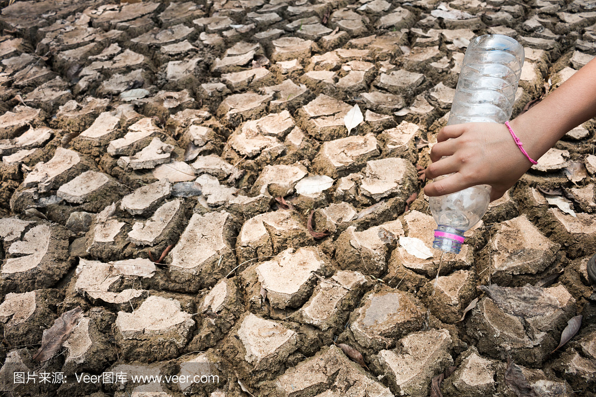 孩子们在干旱的地上倒水,干旱的概念。