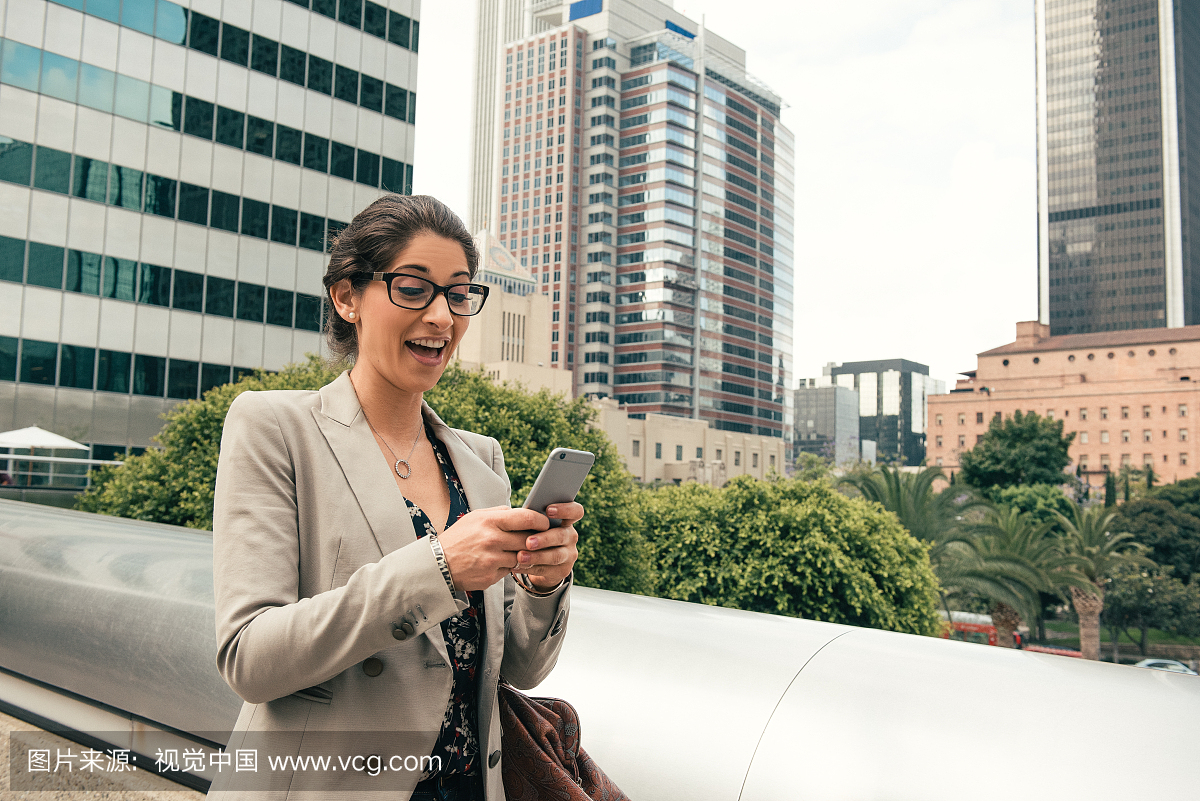 从美国洛杉矶行人天桥读取智能手机文字的女商