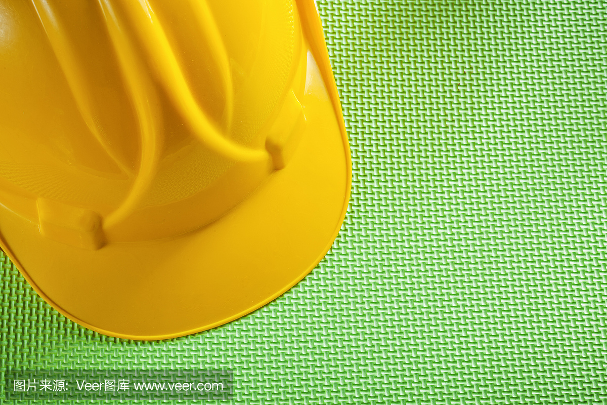 黄色建筑头盔绿色背景施工概念