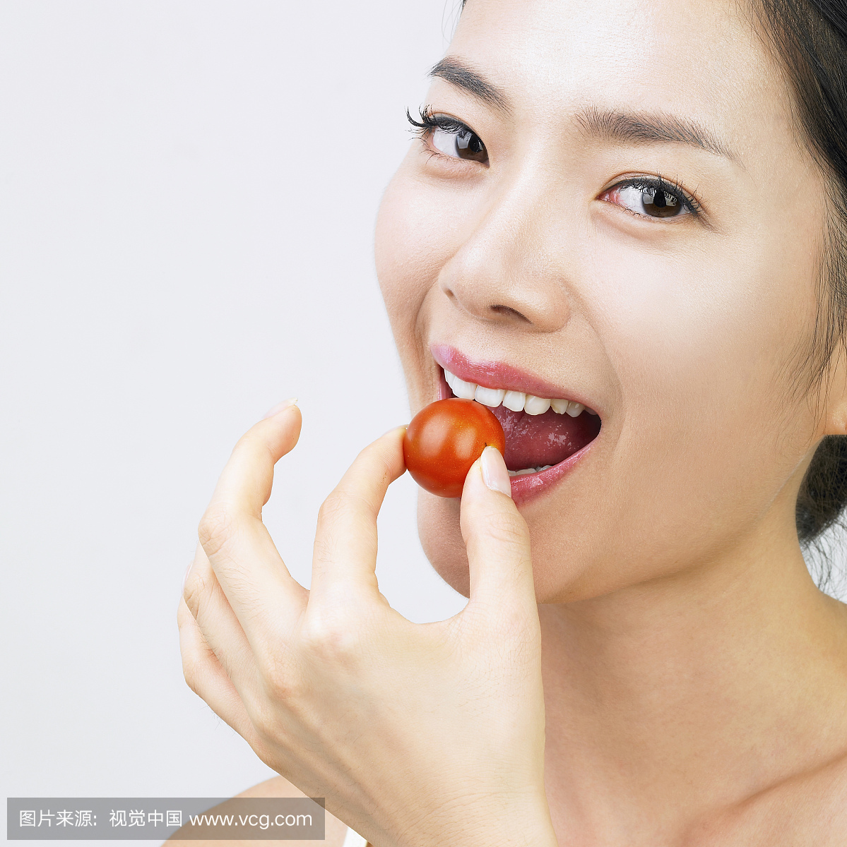 一个女人的脸吃一个小番茄
