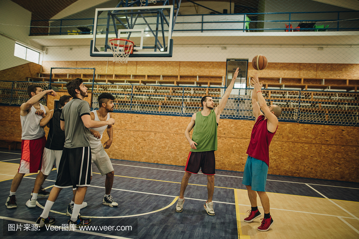 年轻的篮球运动员在体育比赛期间在学校体育馆