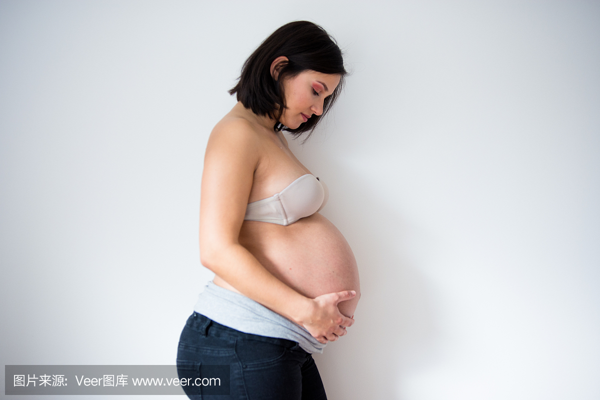 摸她的肚子的孕妇的肖像