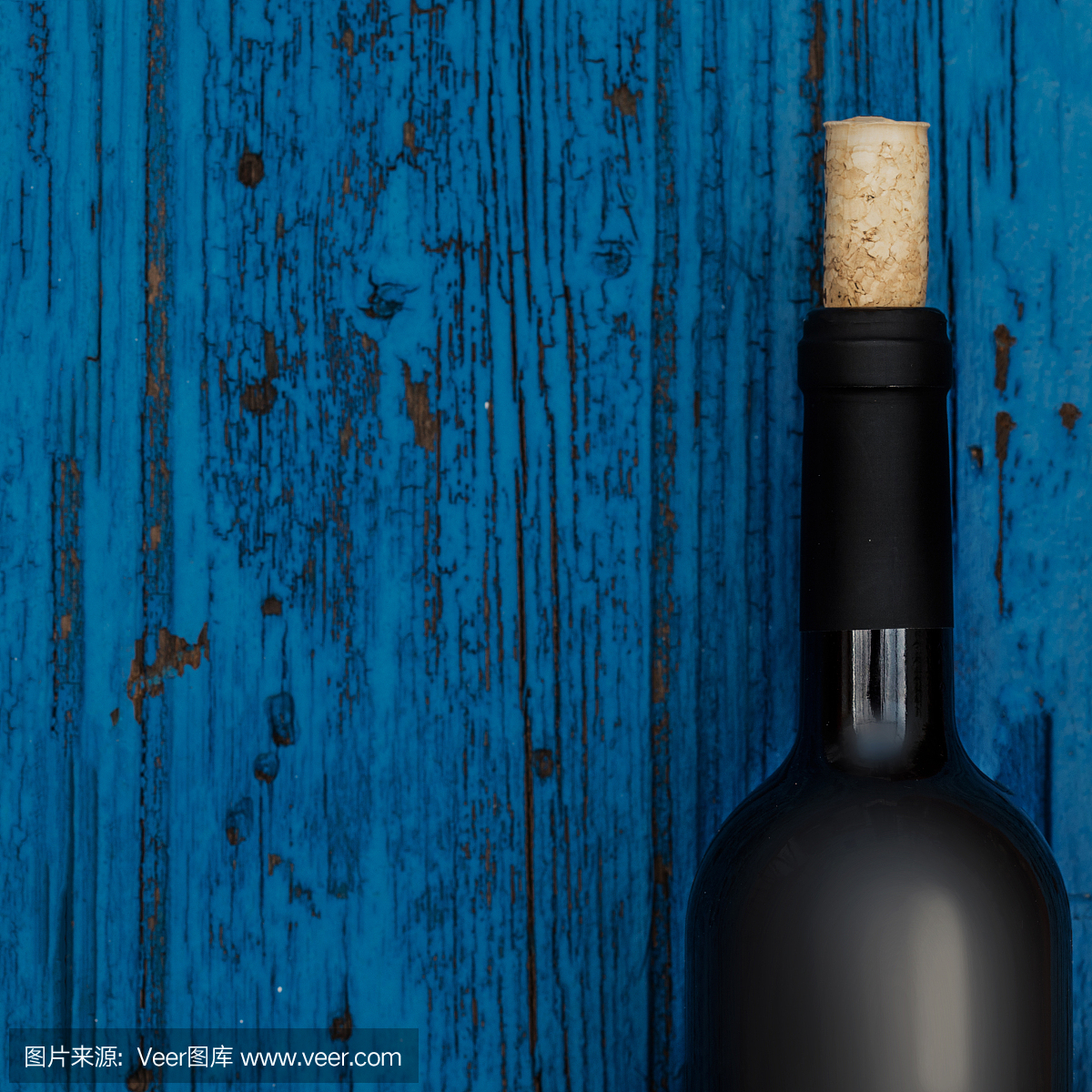 瓶葡萄酒在蓝色木制背景与copyspace,葡萄酒品