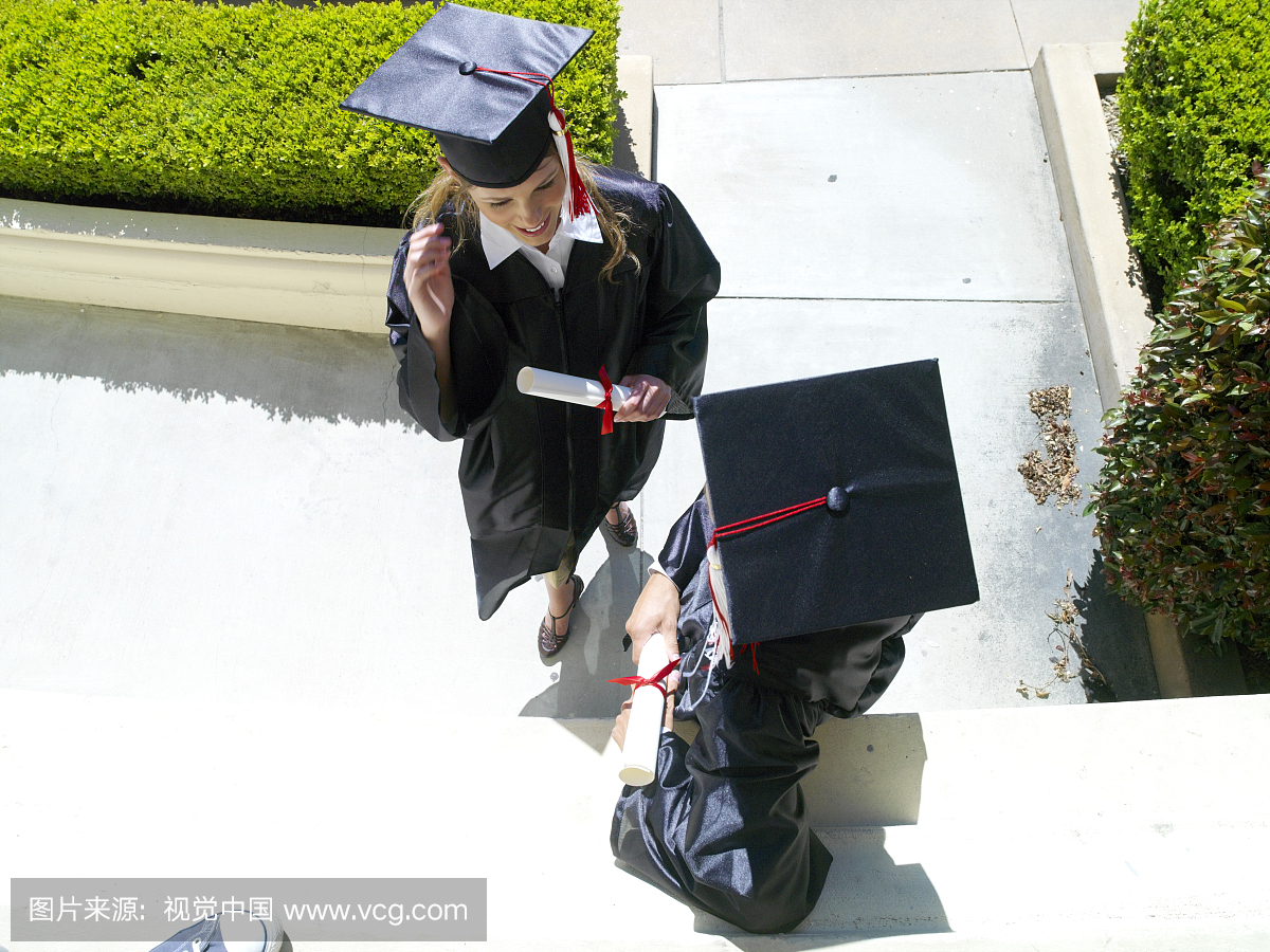 Female graduates in conversation, in caps and