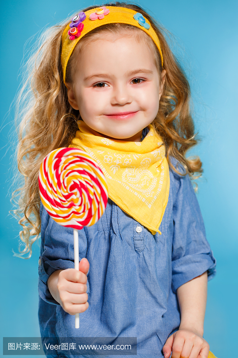 一个快乐的小女孩与棒棒糖的工作室肖像
