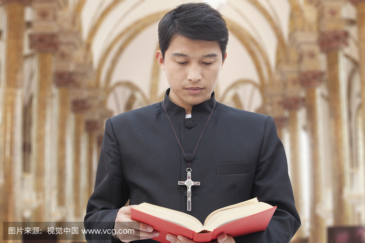 Priest Looking at Bible in a Church