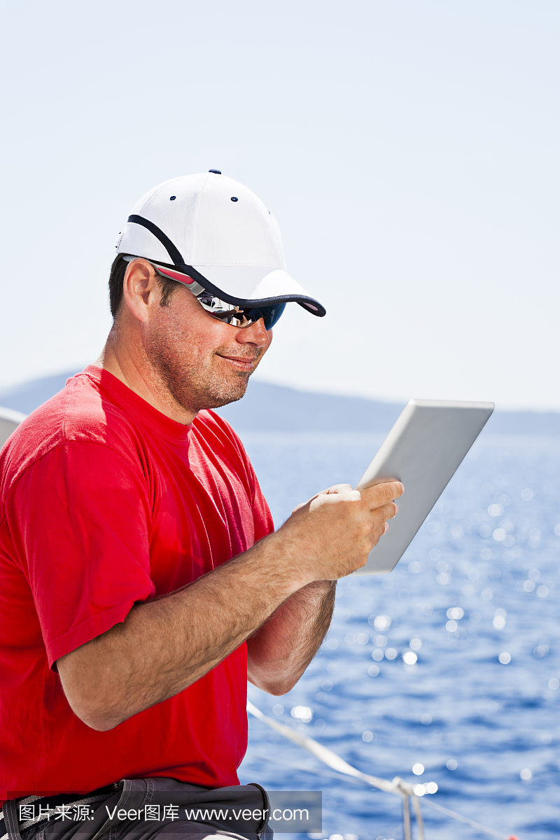 船长使用数字平板电脑在帆船上