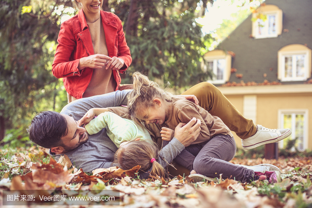 女儿挠痒痒的父亲,与父母玩耍。