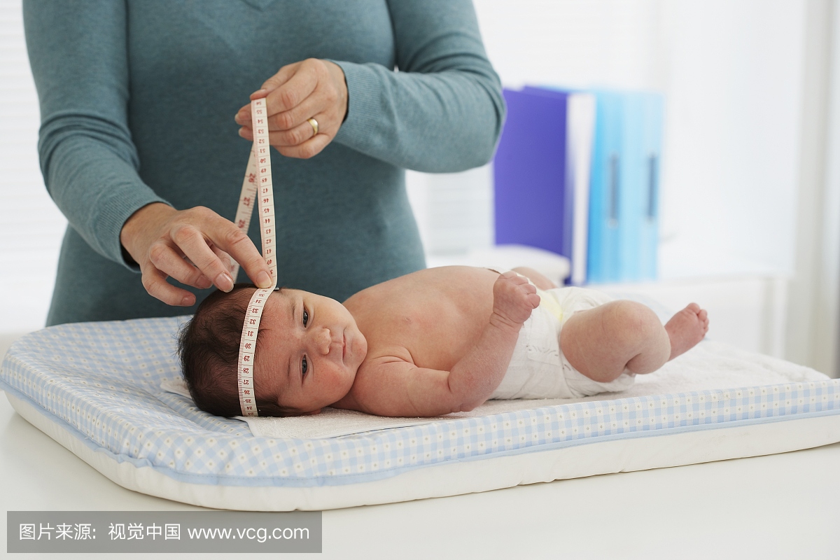 医生测量一个女婴的头围