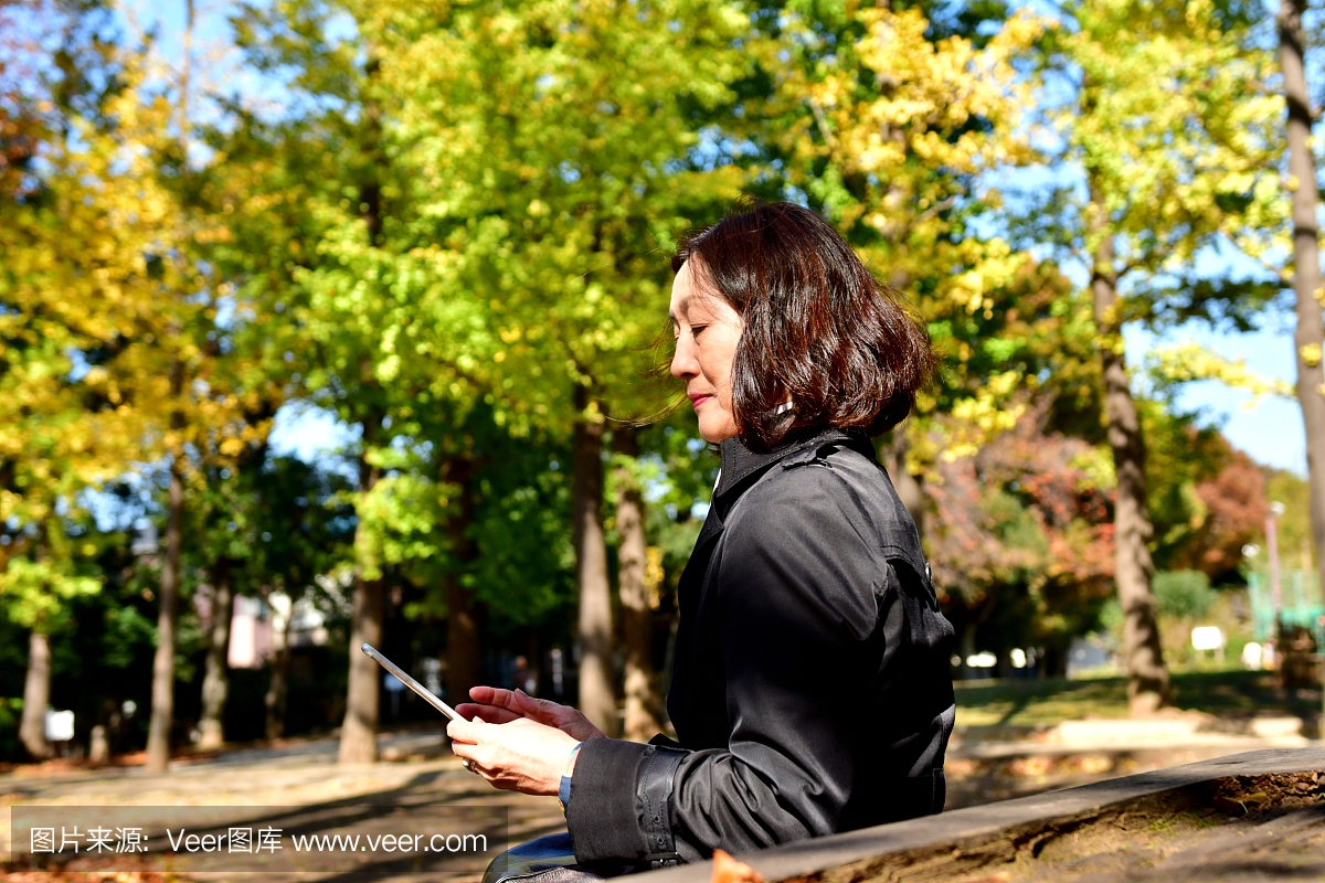 日本女子在东京公园检查她的手机邮件