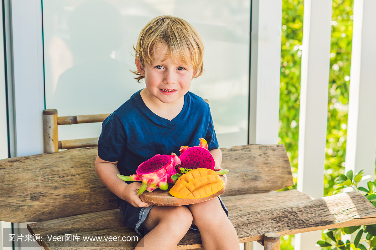 在男孩手中切丁火龙果和芒果
