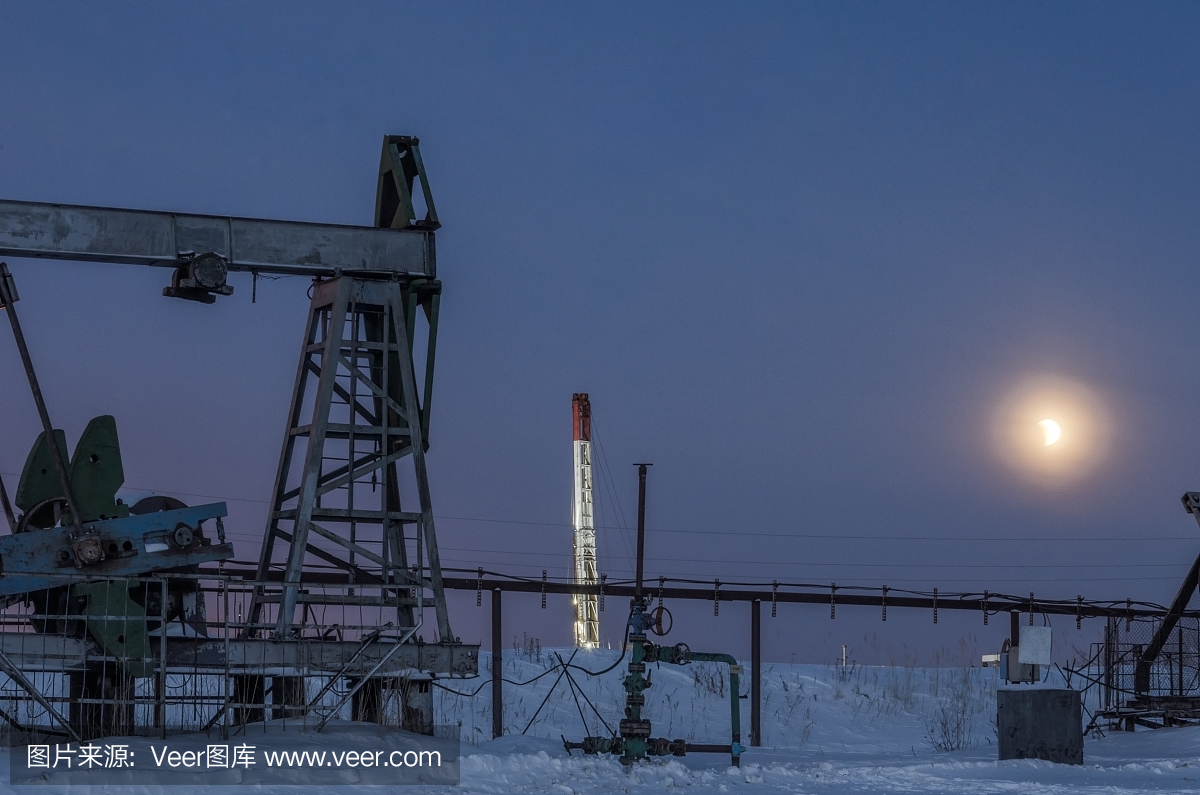 油田月蚀期间的抽油机千斤顶,井口,管道和石油