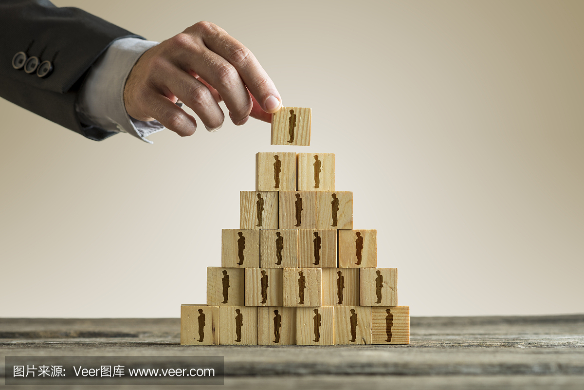 Businessman building a pyramid of wood block