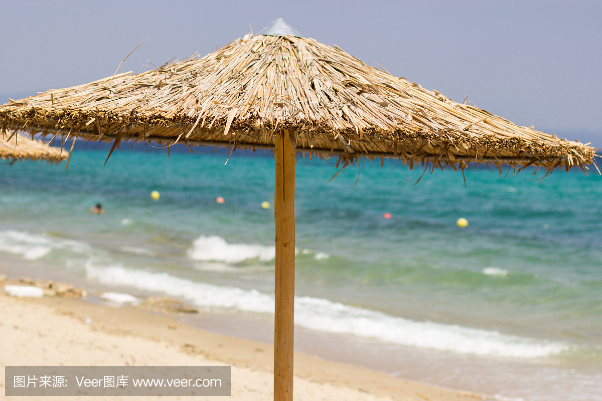 海滩芦苇伞在蓝蓝的天空背景上