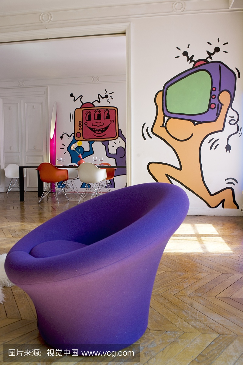 Round purple easy chair in front of pop-art mura