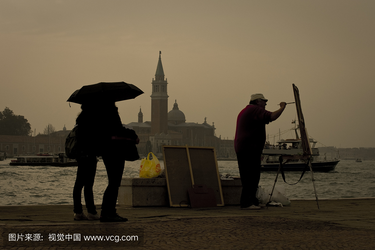 旅游在伞下观看艺术家绘画与圣乔治Maggiore