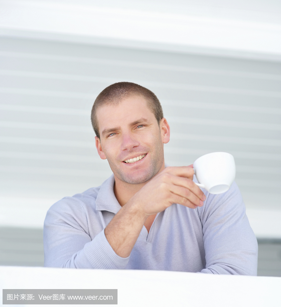 微笑着拿着咖啡杯的年轻人