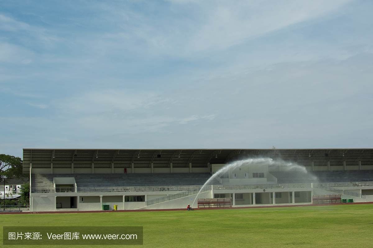 洒水器喷射水到足球场的草地。