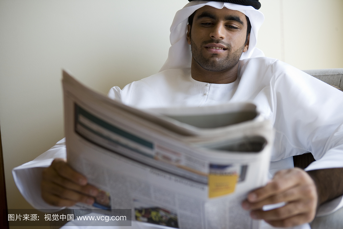 读报纸的阿联酋人。