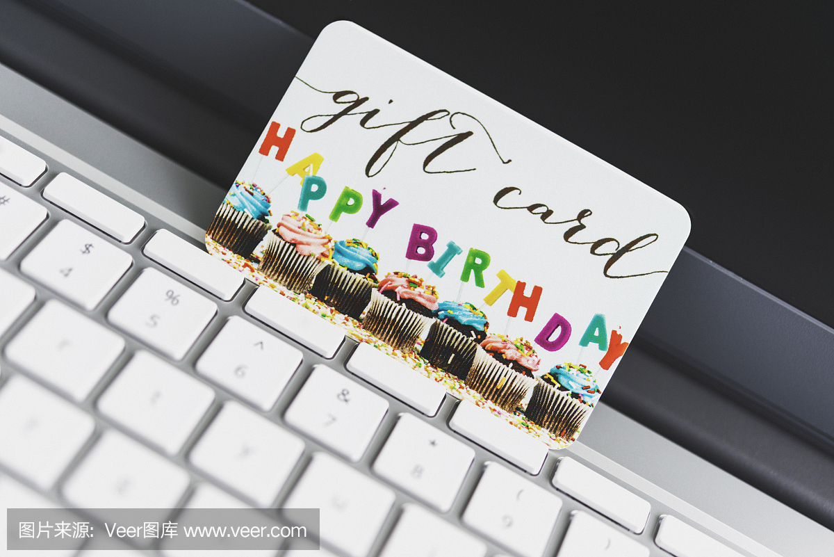 笔记本电脑键盘上的礼品卡。在线购物庆祝活动