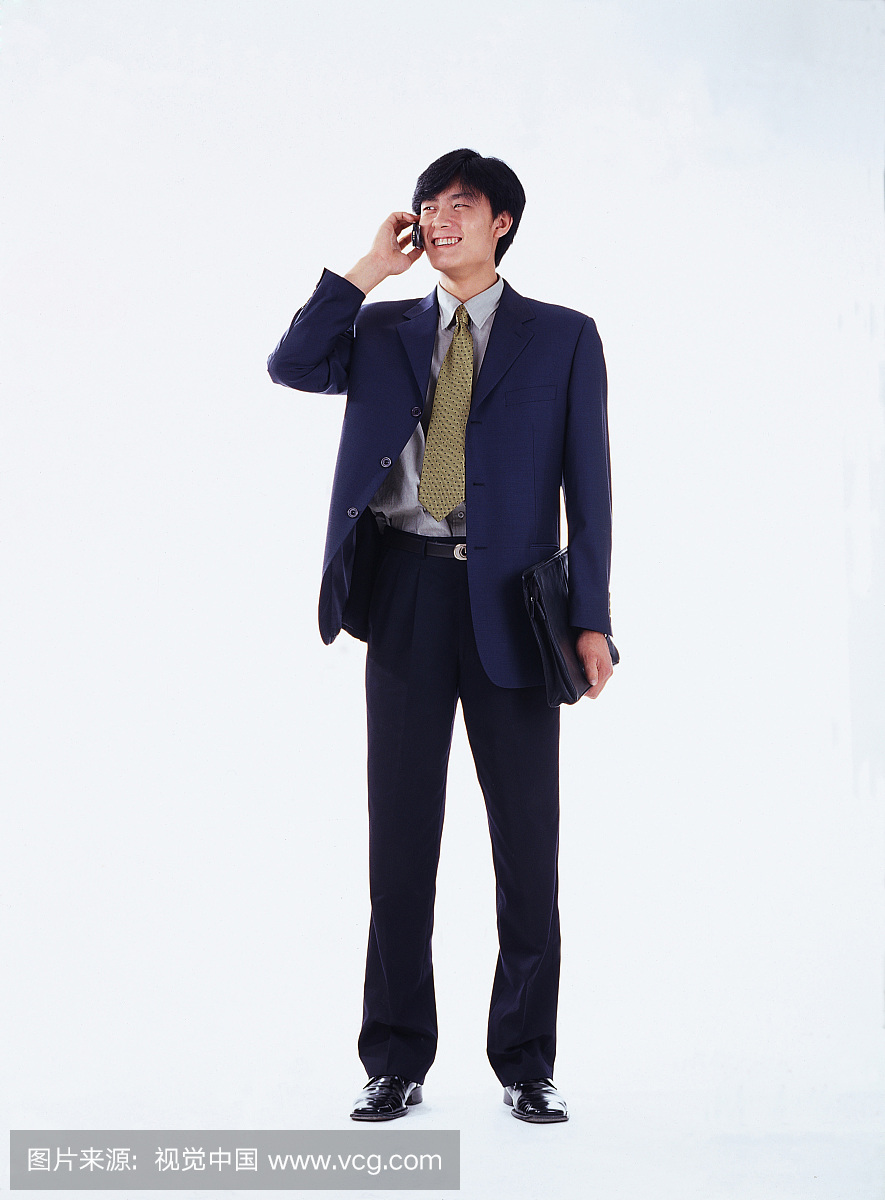 东方男人穿西服站立打电话