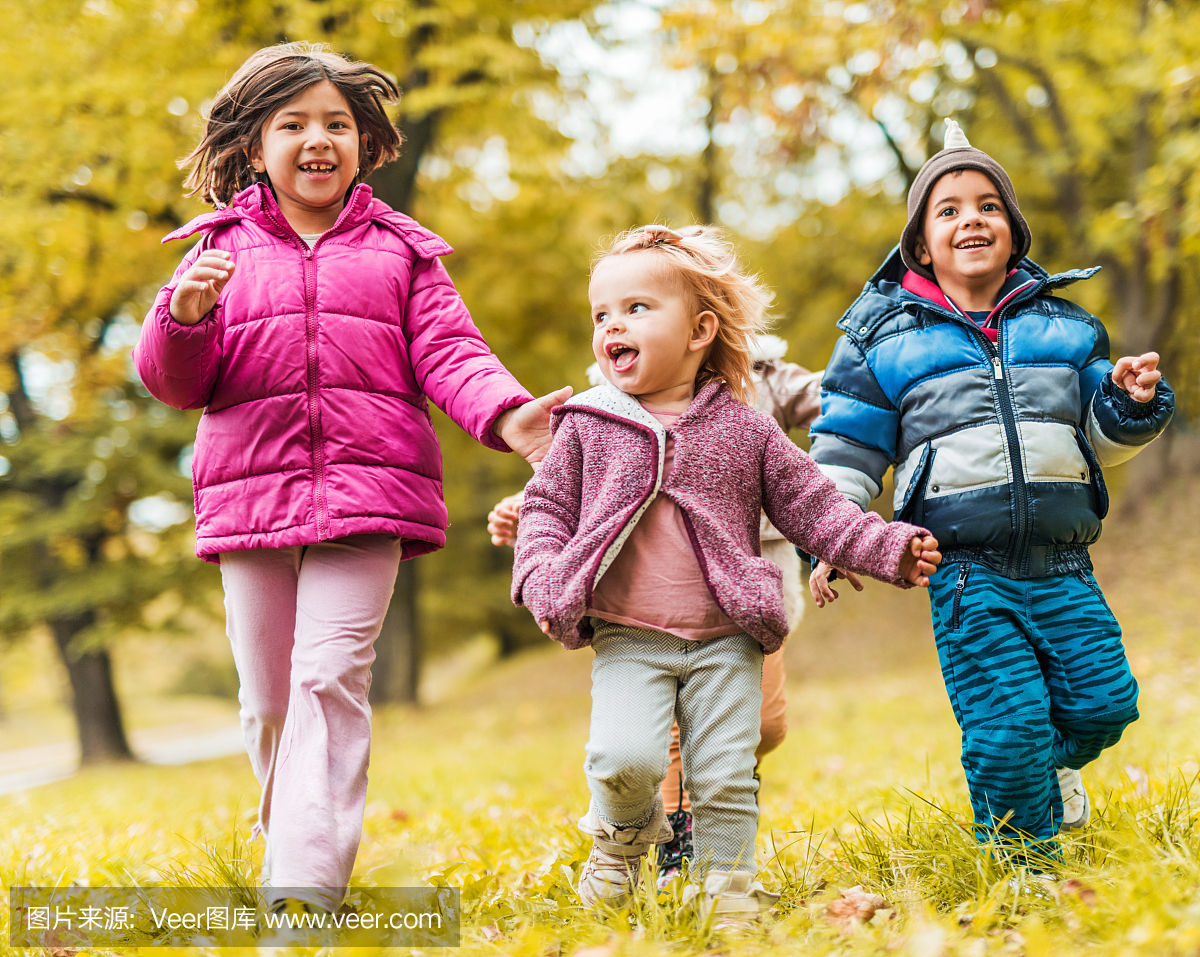在公园里跑步的孩子在秋天玩耍。