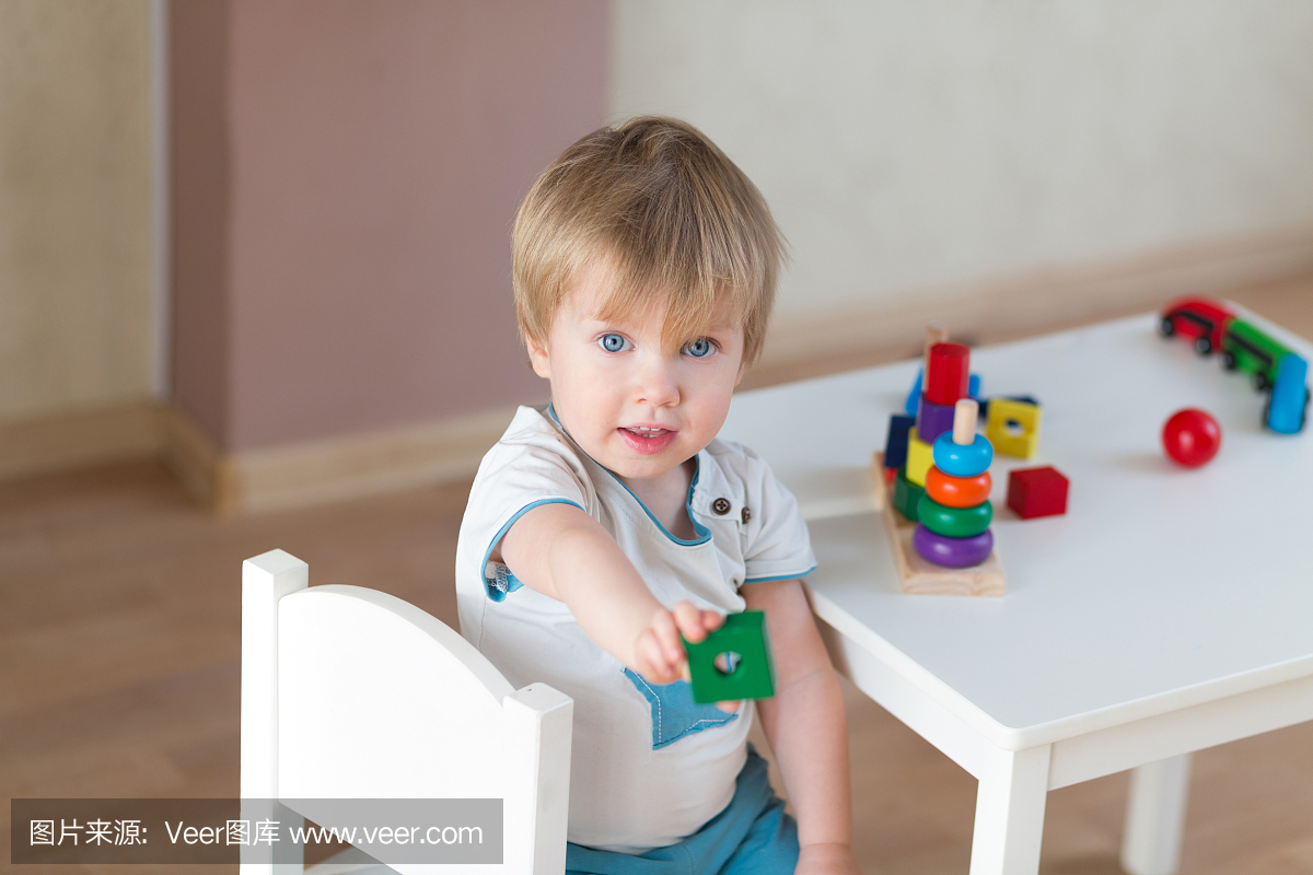 2岁小孩在家玩教育杯玩具。蓝眼睛的小金发宝