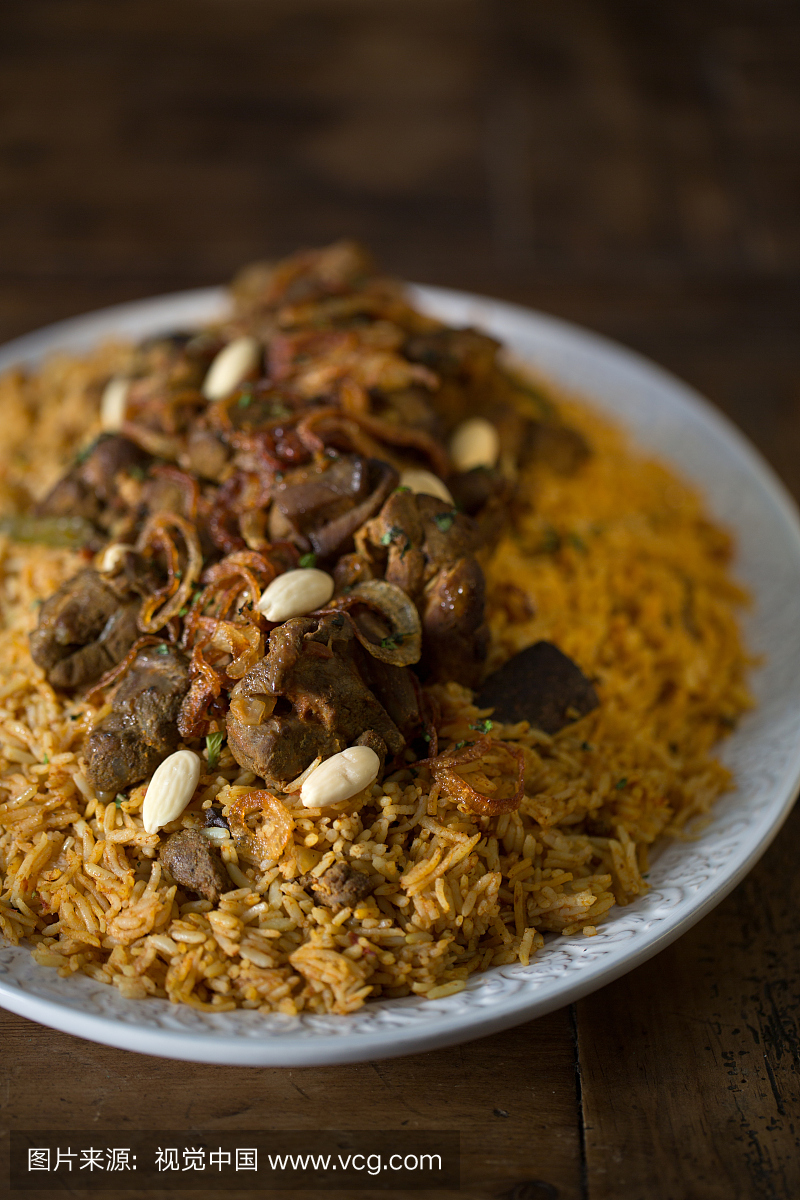 羔羊Kabsa,一个传统的阿拉伯菜,在木桌上。
