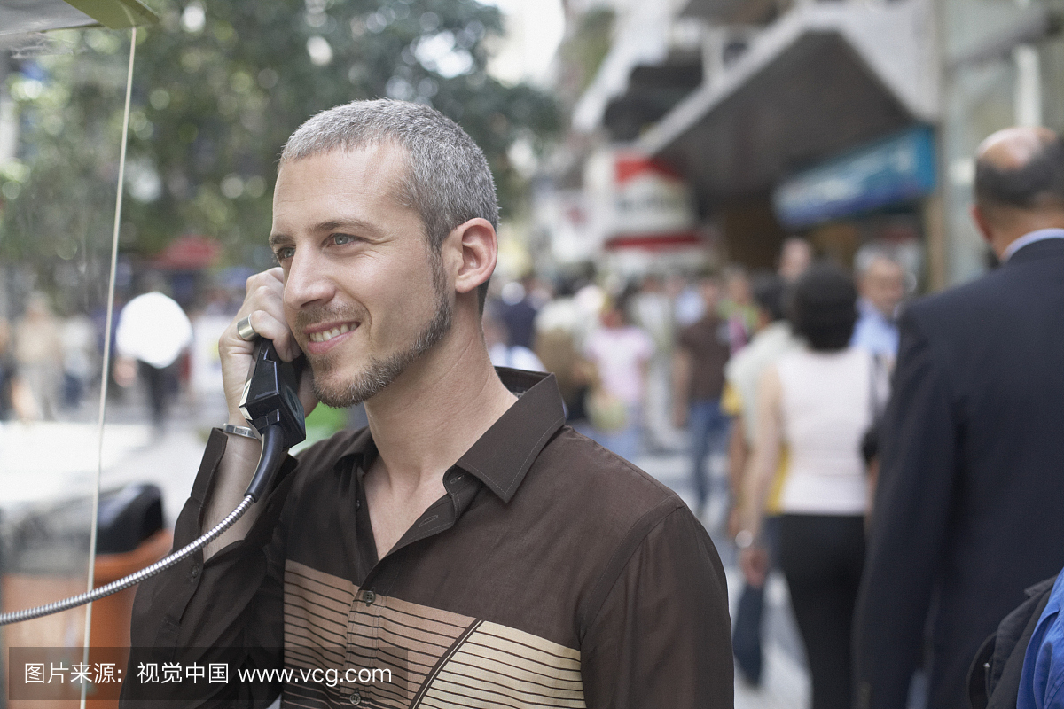 一个年轻人用投币电话说话的特写镜头