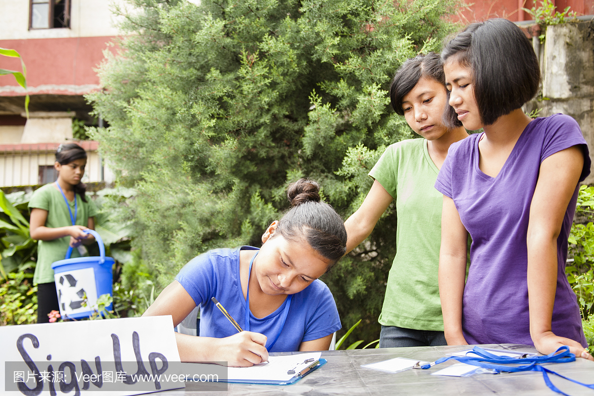青少年在回收志愿者登记表上注册。多族裔群体