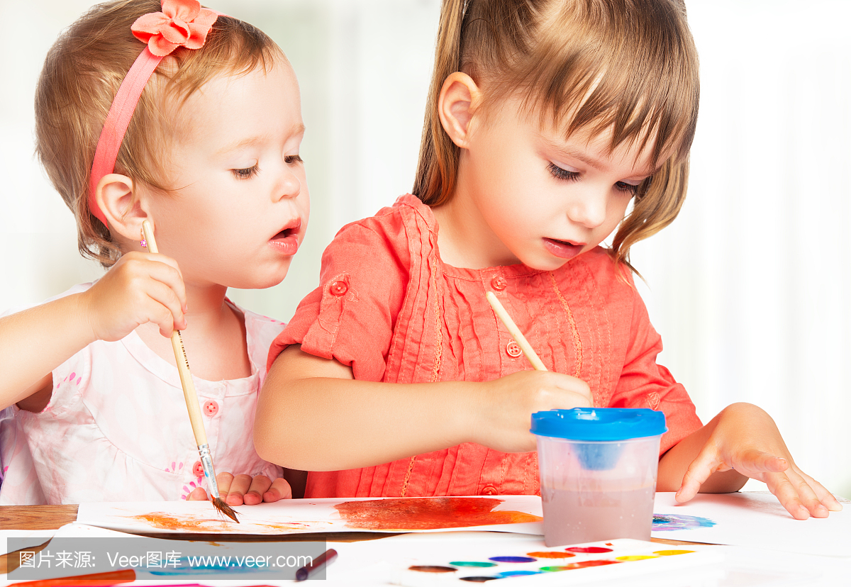 快乐的小女孩在幼儿园绘画油漆