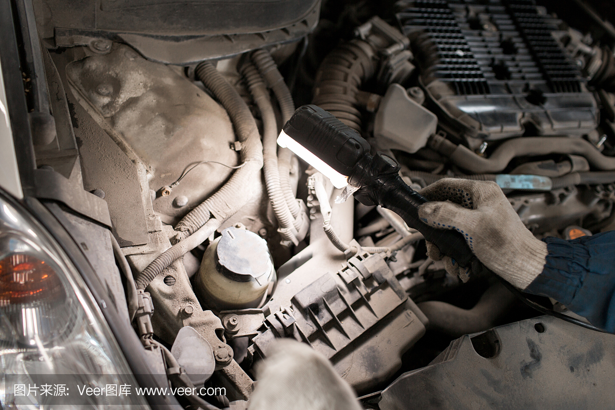 检查汽车的可维护性的技工手在打开的敞篷,关