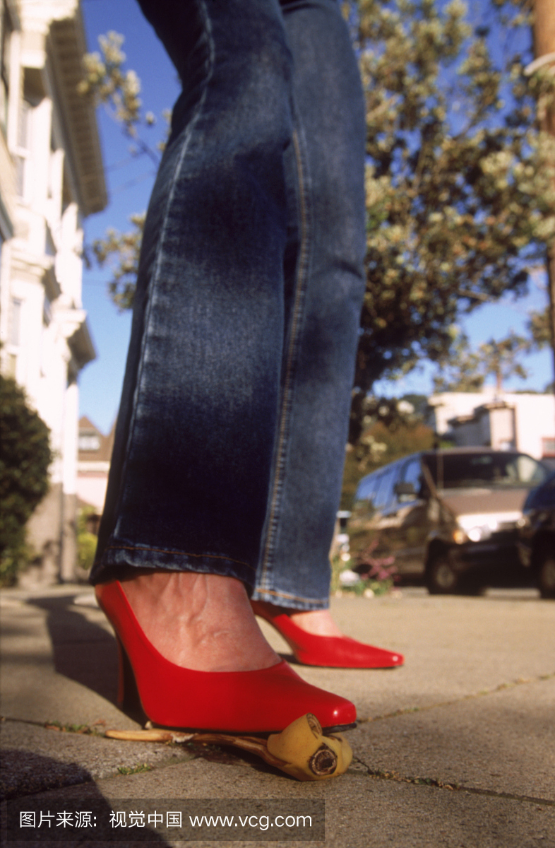 红色高跟鞋在香蕉皮上的女人