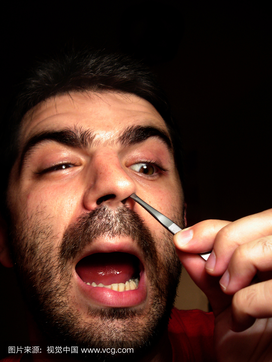男人用镊子拔出鼻毛