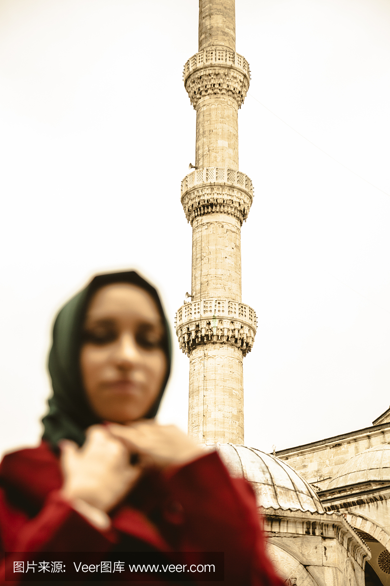 在清真寺前面戴着头巾的女人