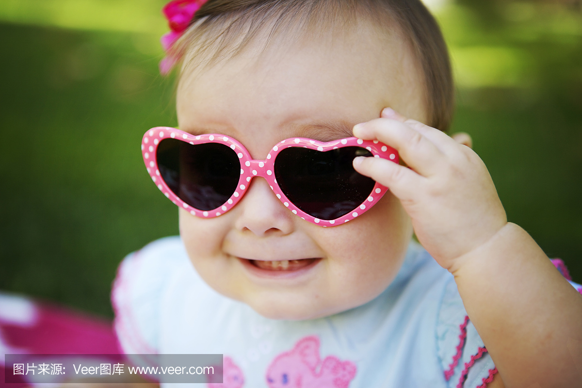 宝贝与粉红色的心形太阳镜
