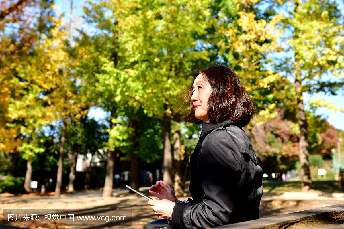 日本女子在东京公园检查她的手机邮件