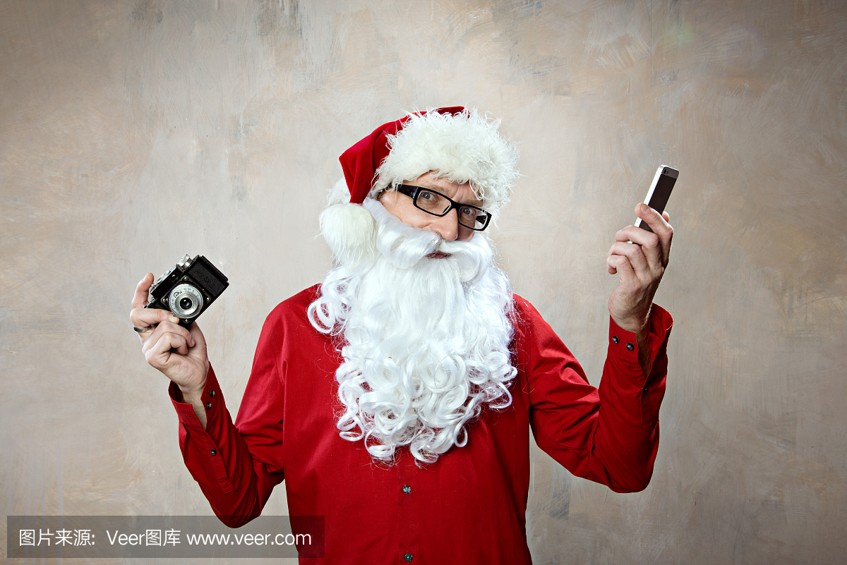 圣诞老人选择智能手机和复古相机