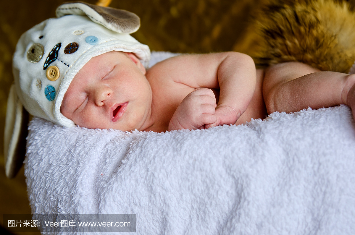 新生婴儿用格子上的耳朵戴上帽子
