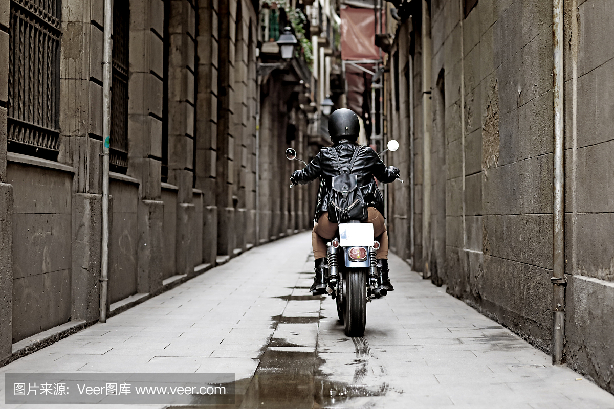 在欧洲市中心骑着老式摩托车的女性摩托车骑士