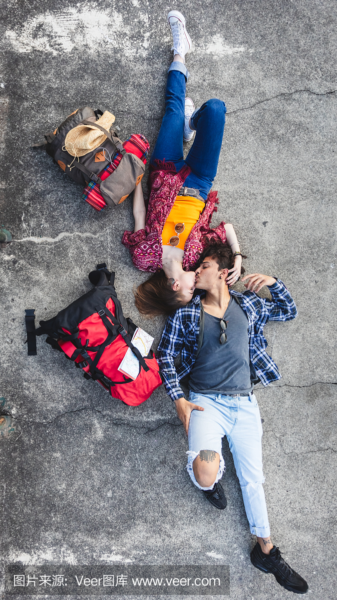 年轻的背包客接吻躺在地上