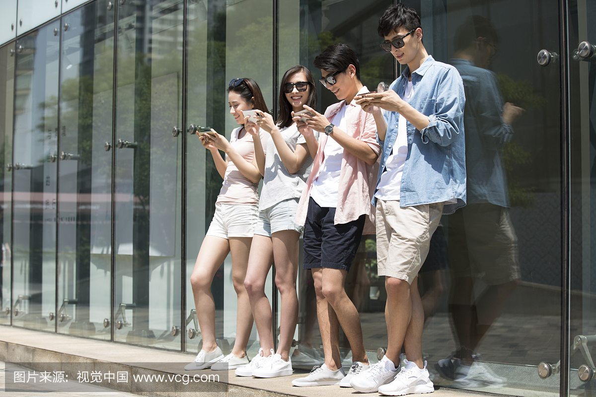 四个年轻人户外玩手机