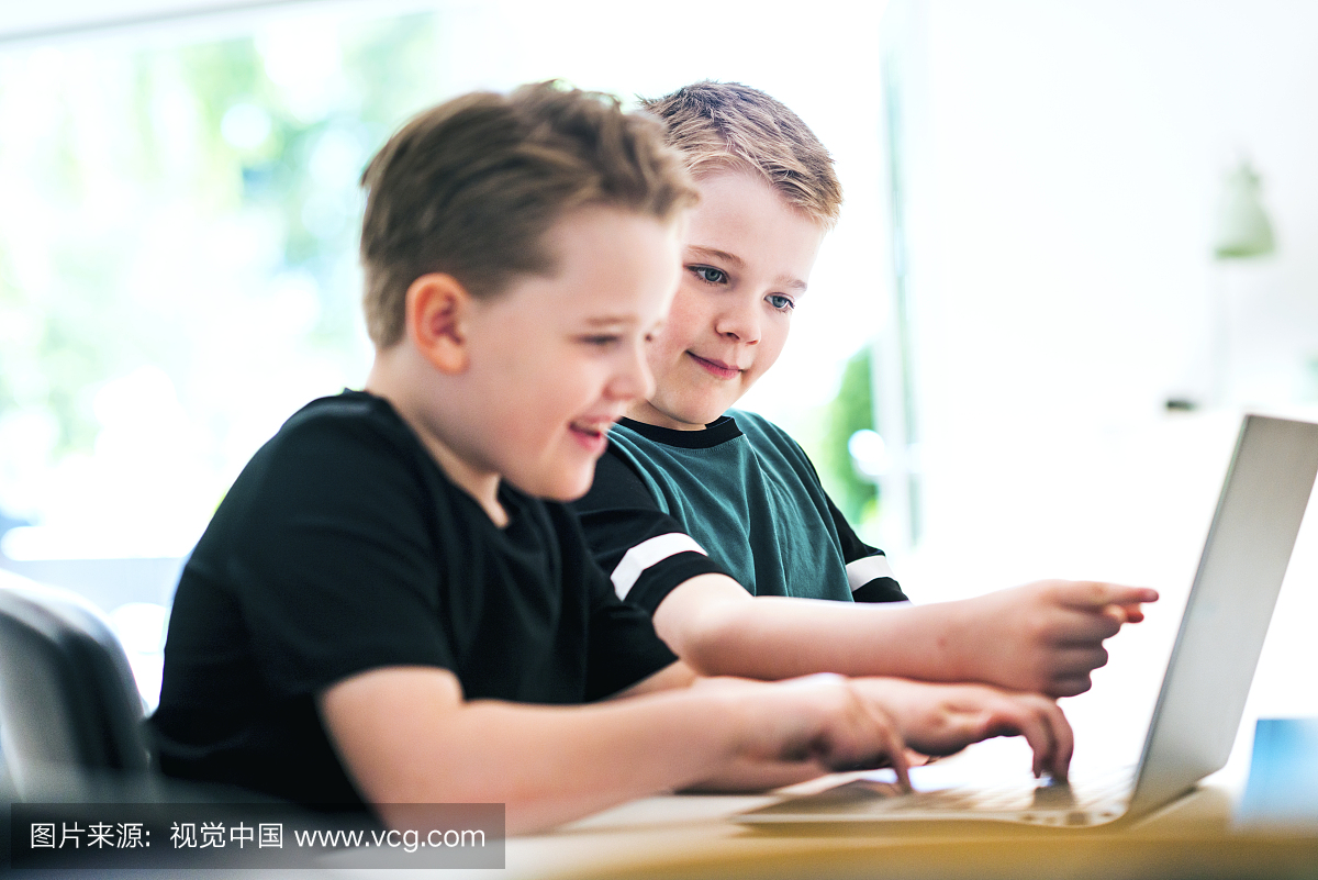 孩子们互相帮助学习如何在笔记本电脑上编码