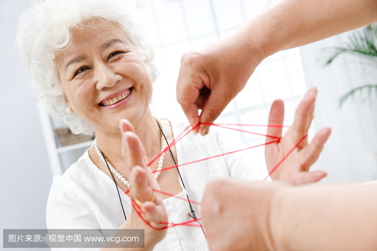 幸福的老年夫妇玩翻绳游戏