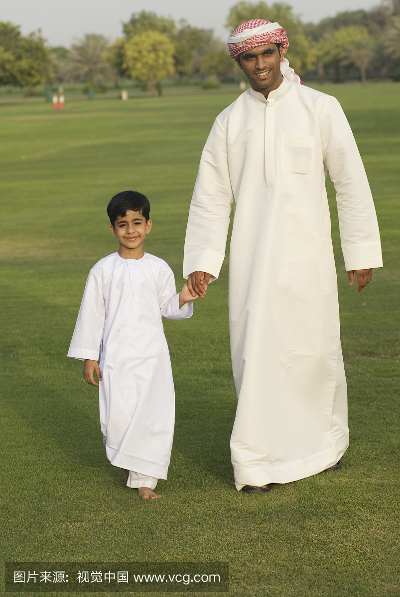 父亲和儿子走在公园,迪拜,阿联酋